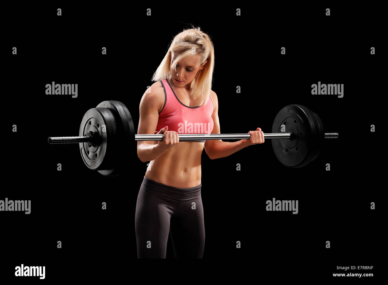 Studio shot di una femmina di bodybuilder sollevamento di un carico pesante su sfondo nero Foto Stock
