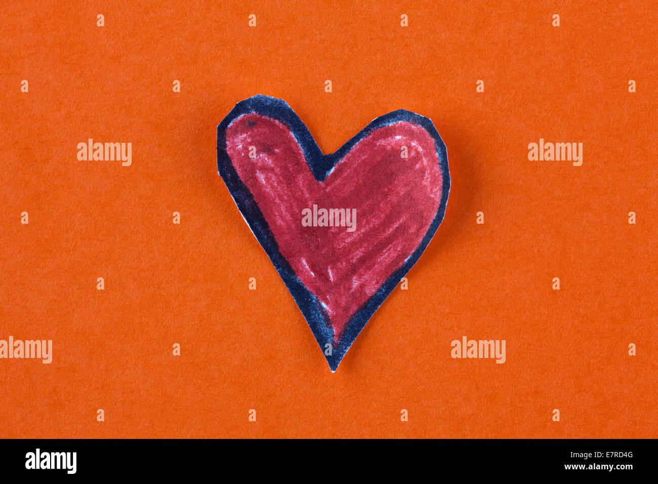 Carta rossa forma di cuore su uno sfondo arancione. Foto Stock