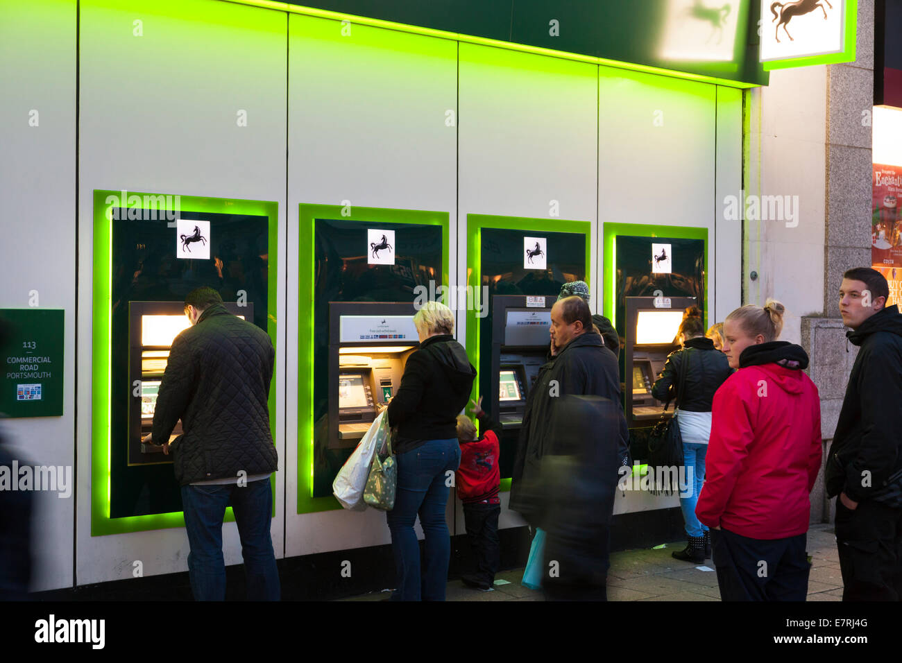 I clienti che utilizzano la Lloyds Bank macchine ATM dopo il tramonto. Foto Stock