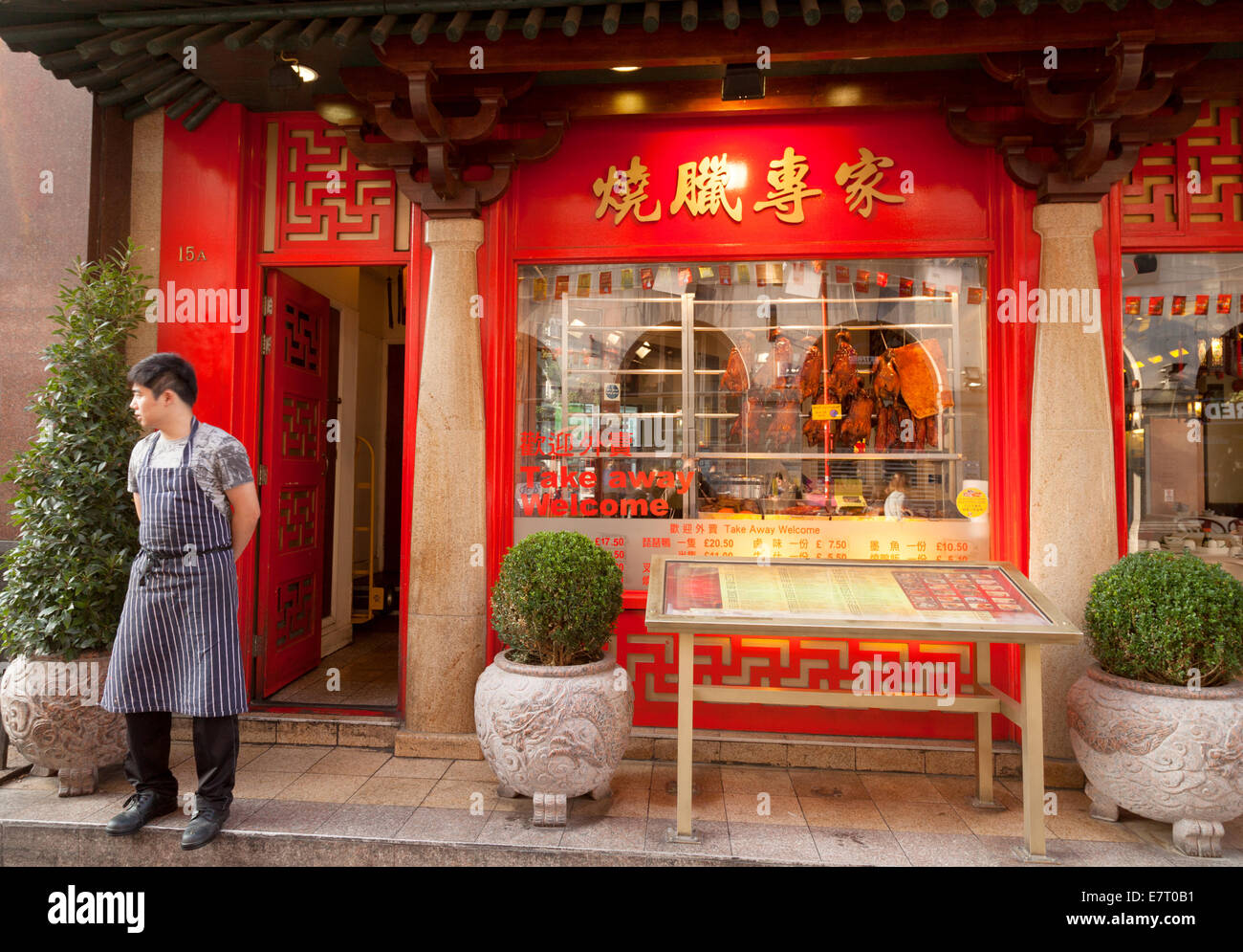 Un cameriere in piedi al di fuori del suo ristorante cinese, Gerrard St, Chinatown, London REGNO UNITO Foto Stock