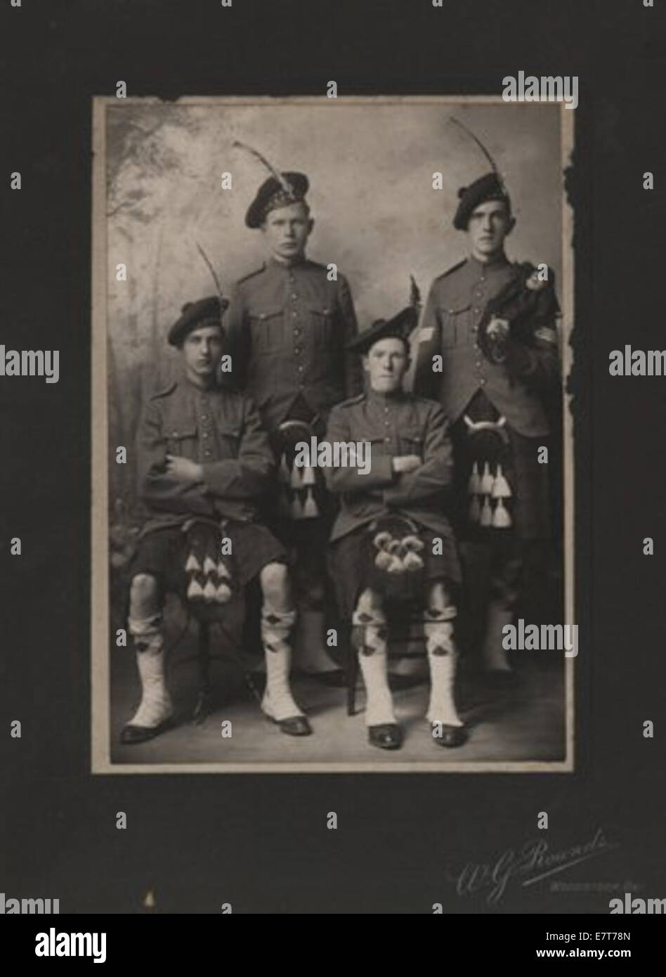 Una fotografia di quattro soldati vestiti in kilt tradizionali. I soldati stanno posando in un accordo formale, mostrando le loro uniformi militari e il distintivo abbigliamento scozzese. Foto Stock