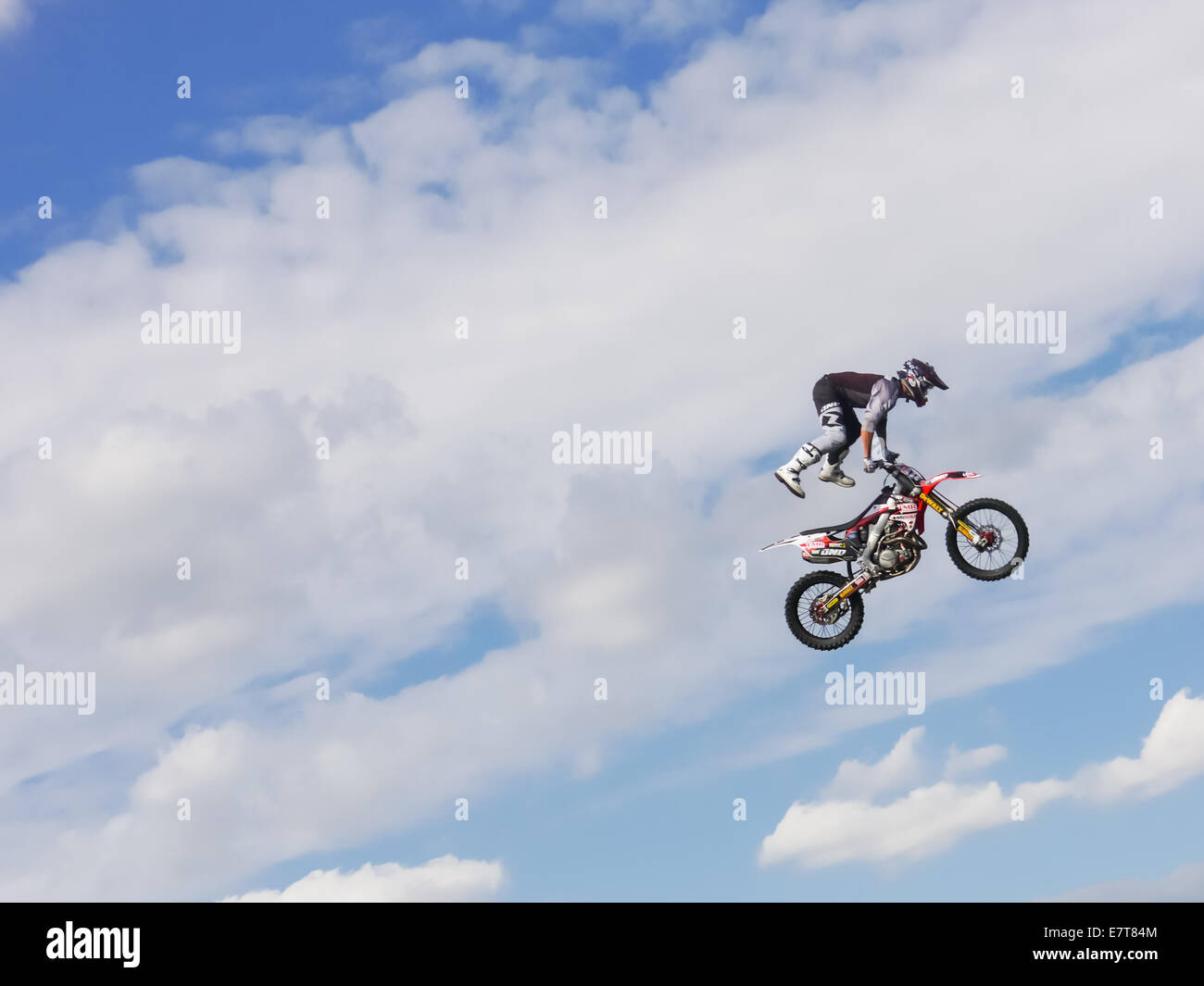 Un Fmx bike rider jumping contro un cielo blu con nuvole Foto Stock