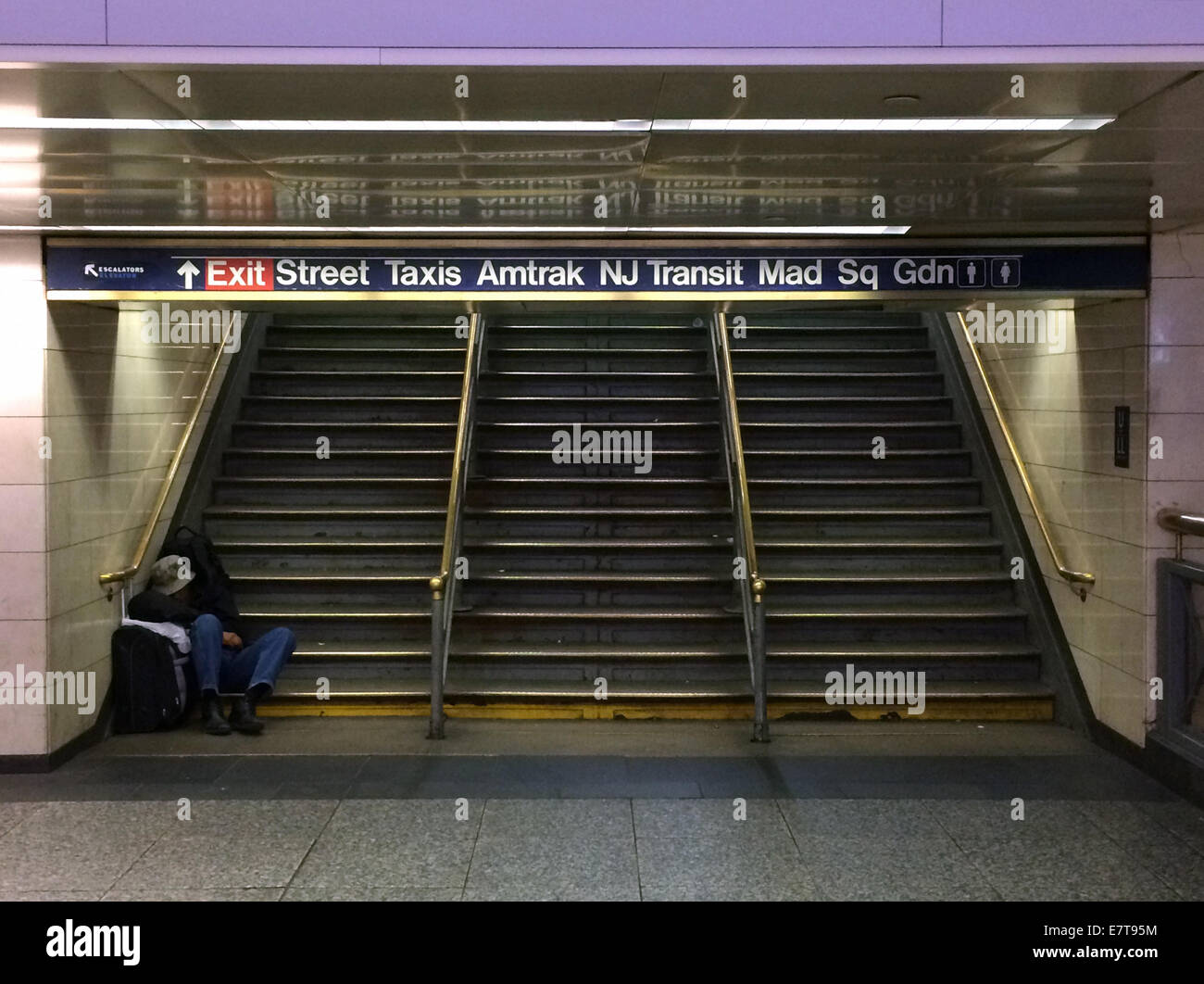 2:00 a Penn Station - un uomo senza dimora dorme sui gradini di un'uscita dalla Pennsylvania Station nel centro di Manhattan (New York City). Foto Stock