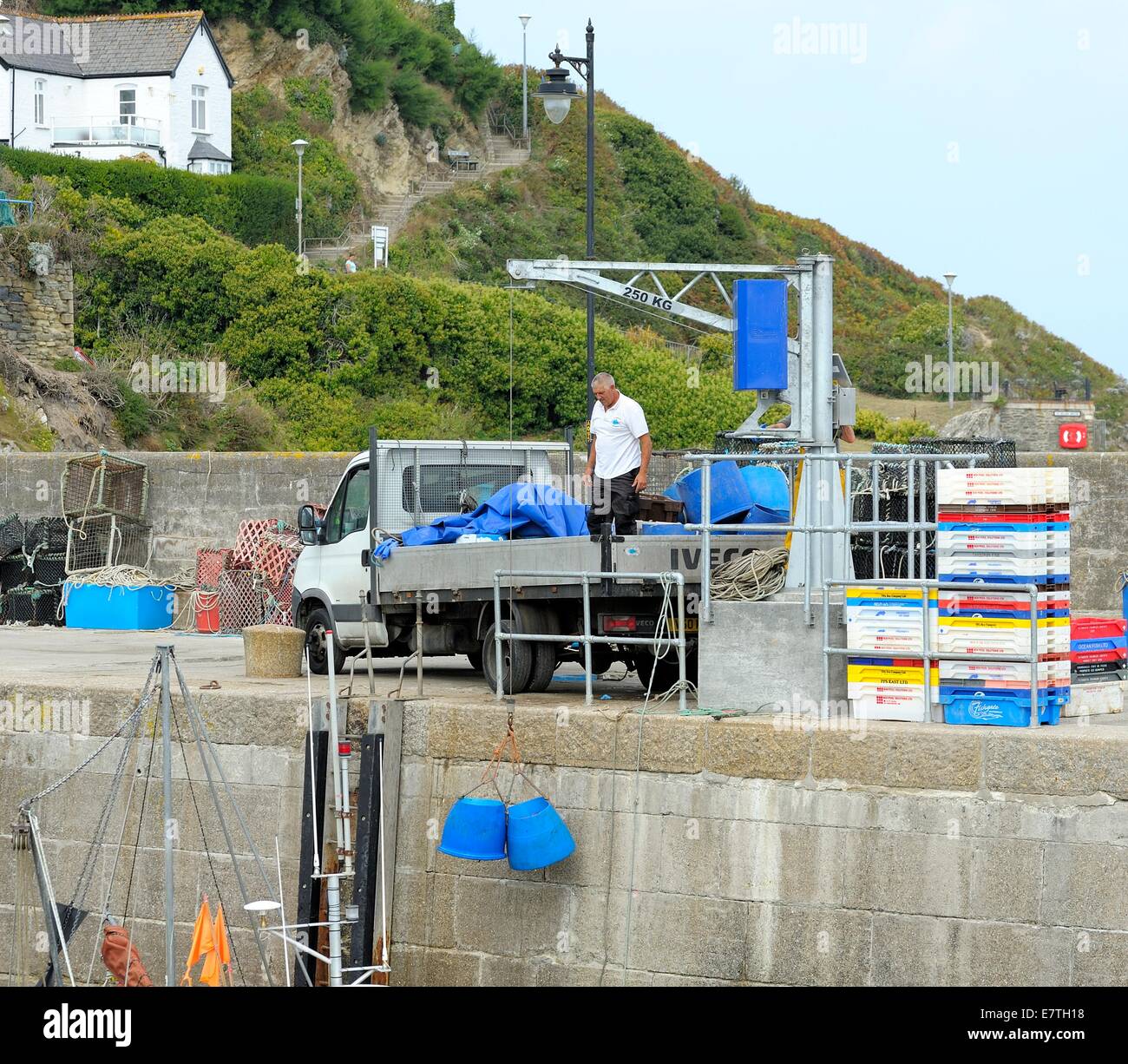 Un uomo sul pianale del carrello utilizzando un paranco per sollevare i giorni catture da parte di un peschereccio Newquay Cornwall Inghilterra Regno Unito Foto Stock