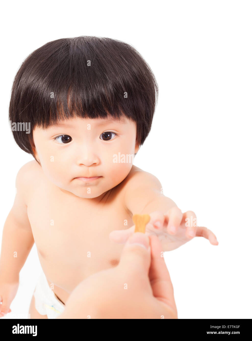 Carino Baby girl focus sul cookie e portarlo su sfondo bianco Foto Stock
