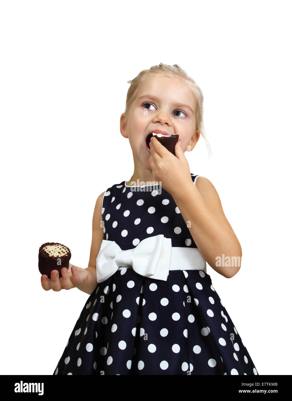 Carino bambina mangia torte. Ritratto isolato su sfondo bianco Foto Stock