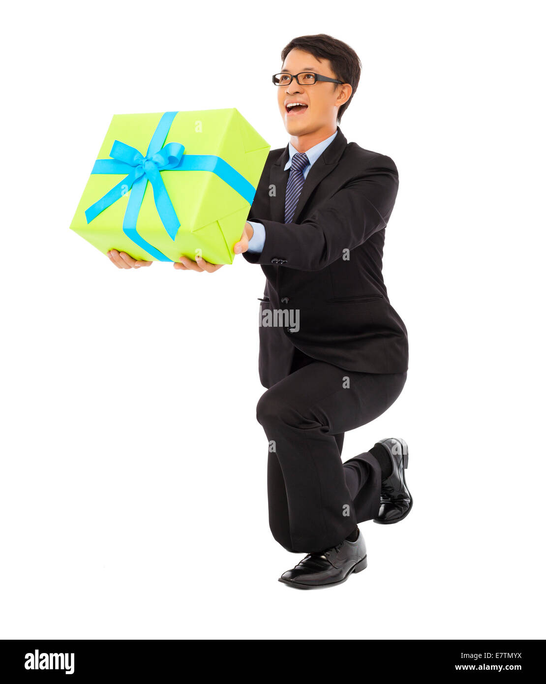 Imprenditore tenendo un regalo e si inginocchiano . isolato su sfondo bianco Foto Stock