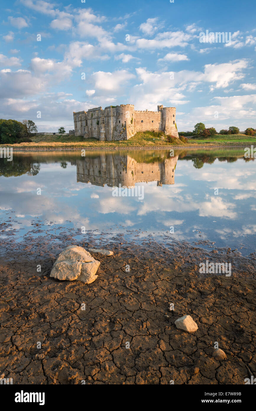 Carew Castle in Pembrokeshire, Galles. Specchio simili riflessioni nelle acque del mulino di marea che la circondano Foto Stock