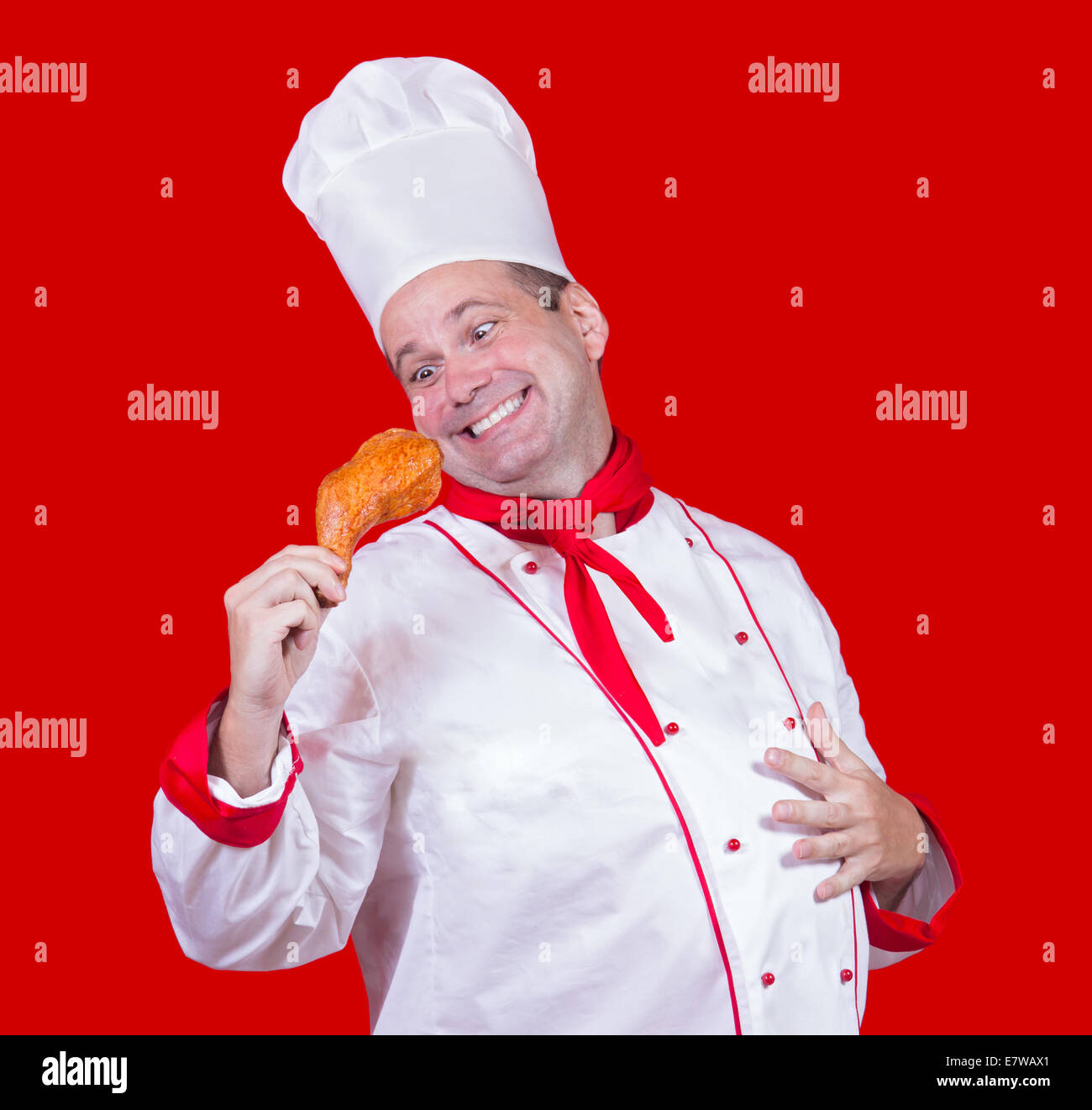Lo chef tenendo in mano una coscia di pollo Foto Stock