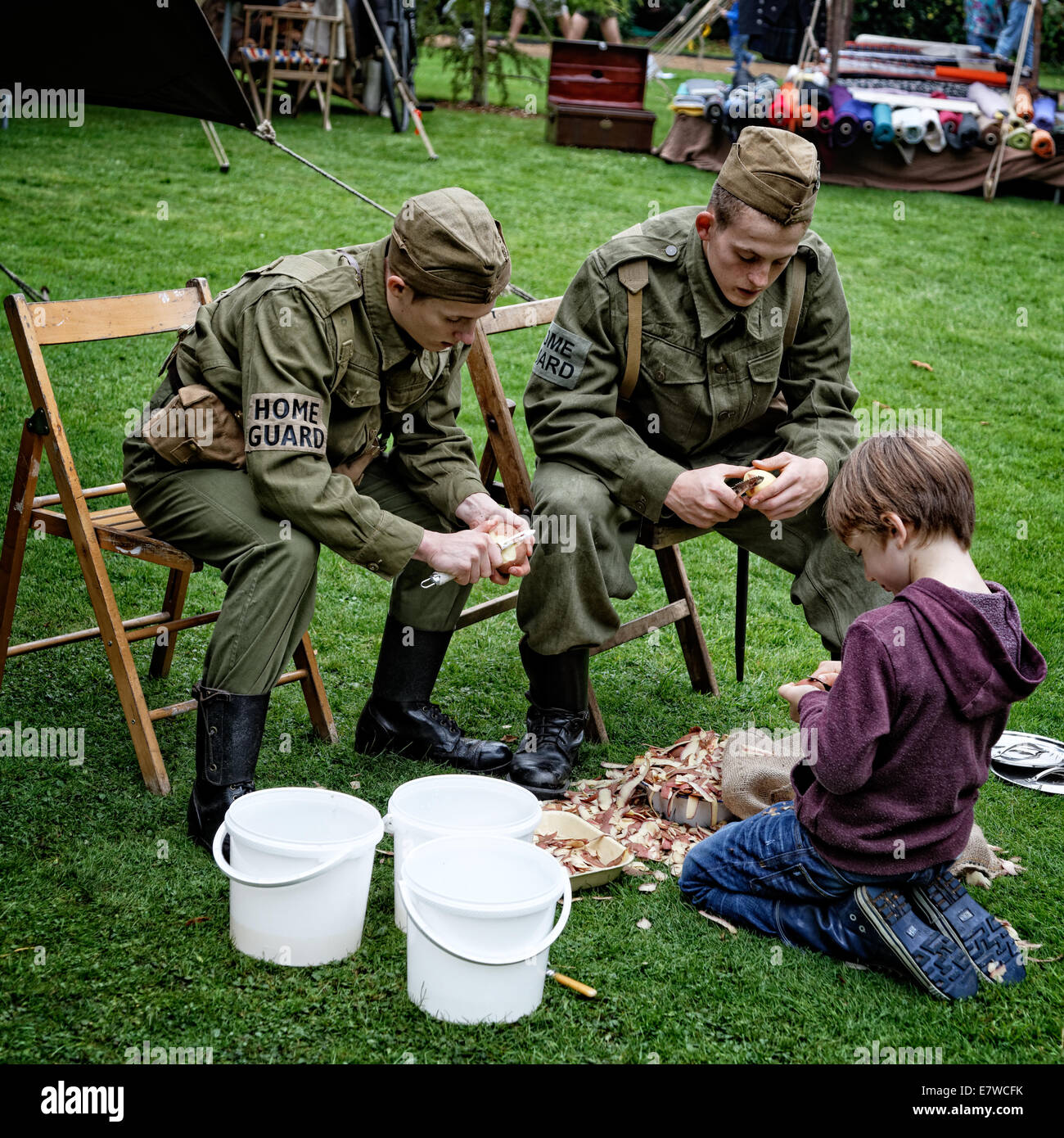 Un giovane visitatore 'spud bashing' con i difensori civili Home Guard Storia viva Group Foto Stock