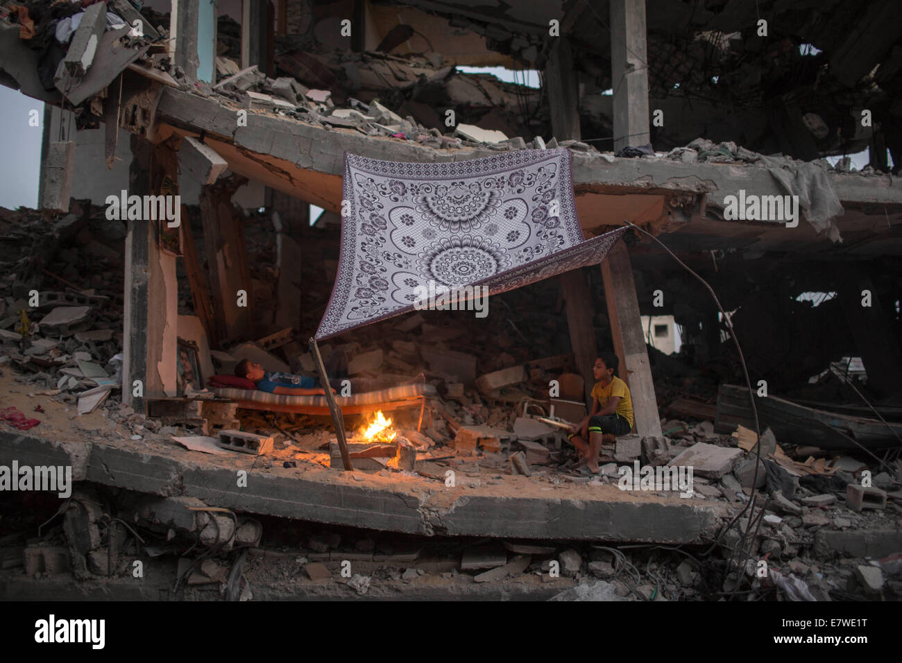 Striscia di Gaza, Shejaiya quartiere di Gaza City. 24Sep, 2014. Gli uomini palestinesi accende un fuoco per illuminare il loro quartiere, che è stato distrutto durante la 50-giorno del conflitto tra Israele e Hamas, nel quartiere Shejaiya di Gaza City, a settembre 24, 2014. © Wissam Nassar/Xinhua/Alamy Live News Foto Stock