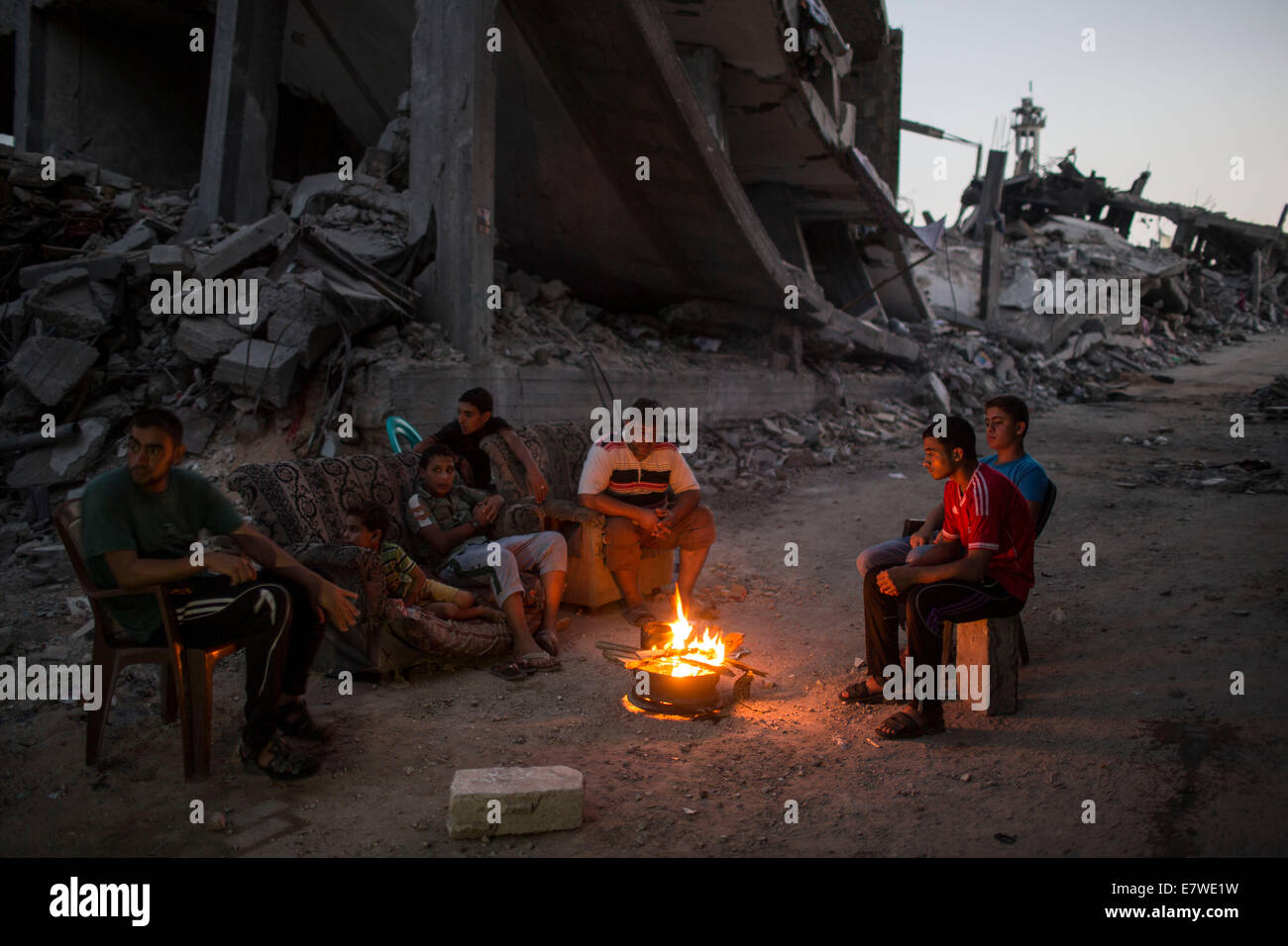 Striscia di Gaza, Shejaiya quartiere di Gaza City. 24Sep, 2014. Gli uomini palestinesi accende un fuoco per illuminare il loro quartiere, che è stato distrutto durante la 50-giorno del conflitto tra Israele e Hamas, nel quartiere Shejaiya di Gaza City, a settembre 24, 2014. © Wissam Nassar/Xinhua/Alamy Live News Foto Stock