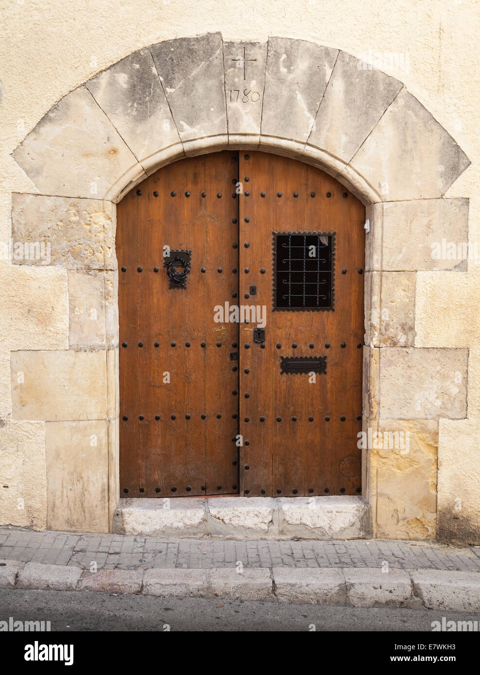 Antica porta in legno con arco in pietra gialla parete Foto Stock