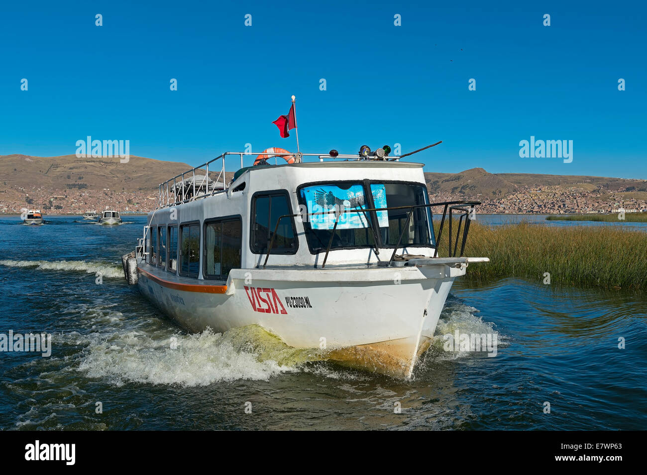 Gita in barca sul lago Titicaca, città di Puno sul retro, Regione di Puno, Perù Foto Stock