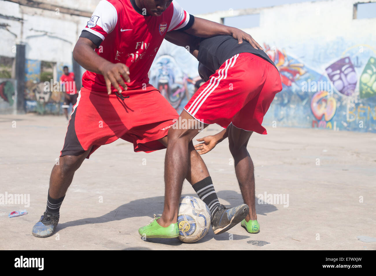 Ragazzi che giocano a calcio indossando kit rosso affrontare Foto Stock