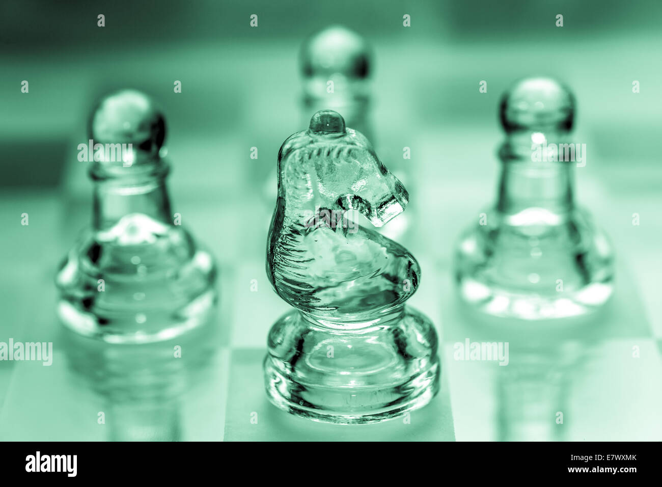 Knight pezzo degli scacchi con pedine in background pezzi realizzati in vetro Foto Stock