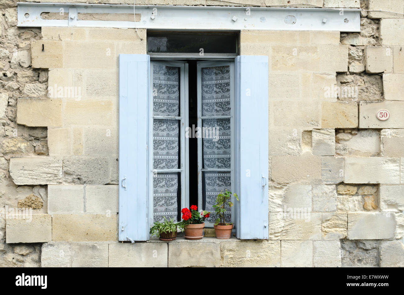 Tipica finestra francese con persiane colorate su una vecchia casa di pietra in St Emilion, Francia Foto Stock