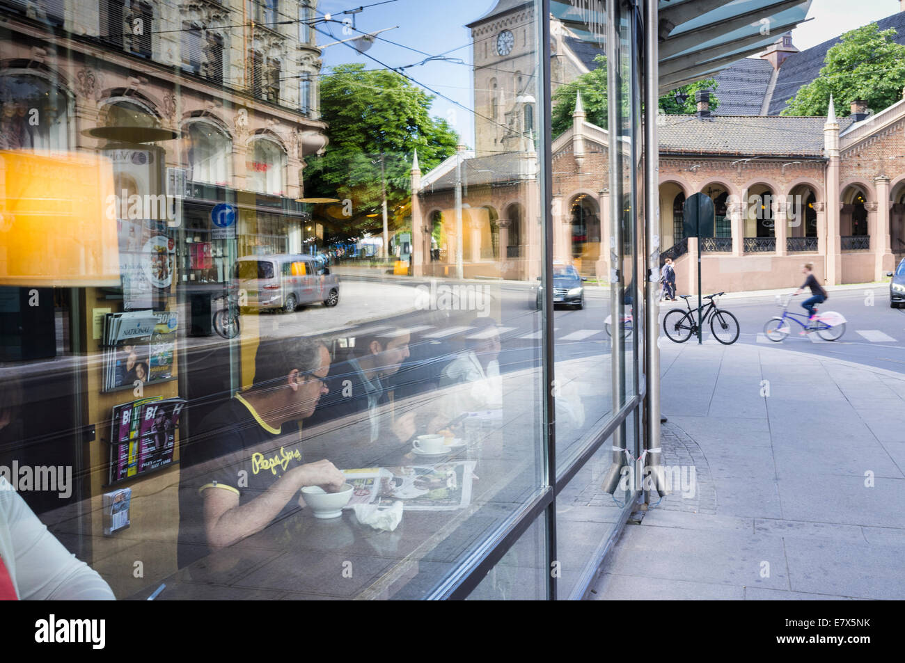 La gente si vede attraverso un cafè finestra accanto al Bazaar sale in Oslo, Norvegia Foto Stock