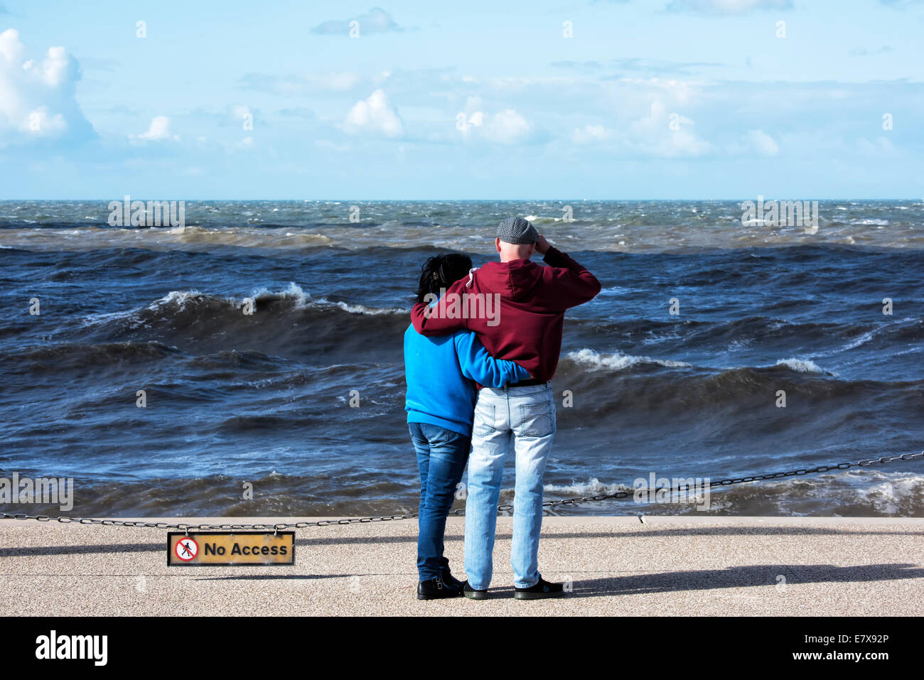 Coppia giovane sotto braccio e guardando il mare Foto Stock