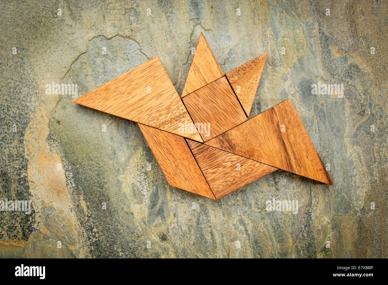Immagine astratta di un flying bat costruito da sette tangram pezzi di legno su una roccia di ardesia sfondo, concetto di Halloween Foto Stock