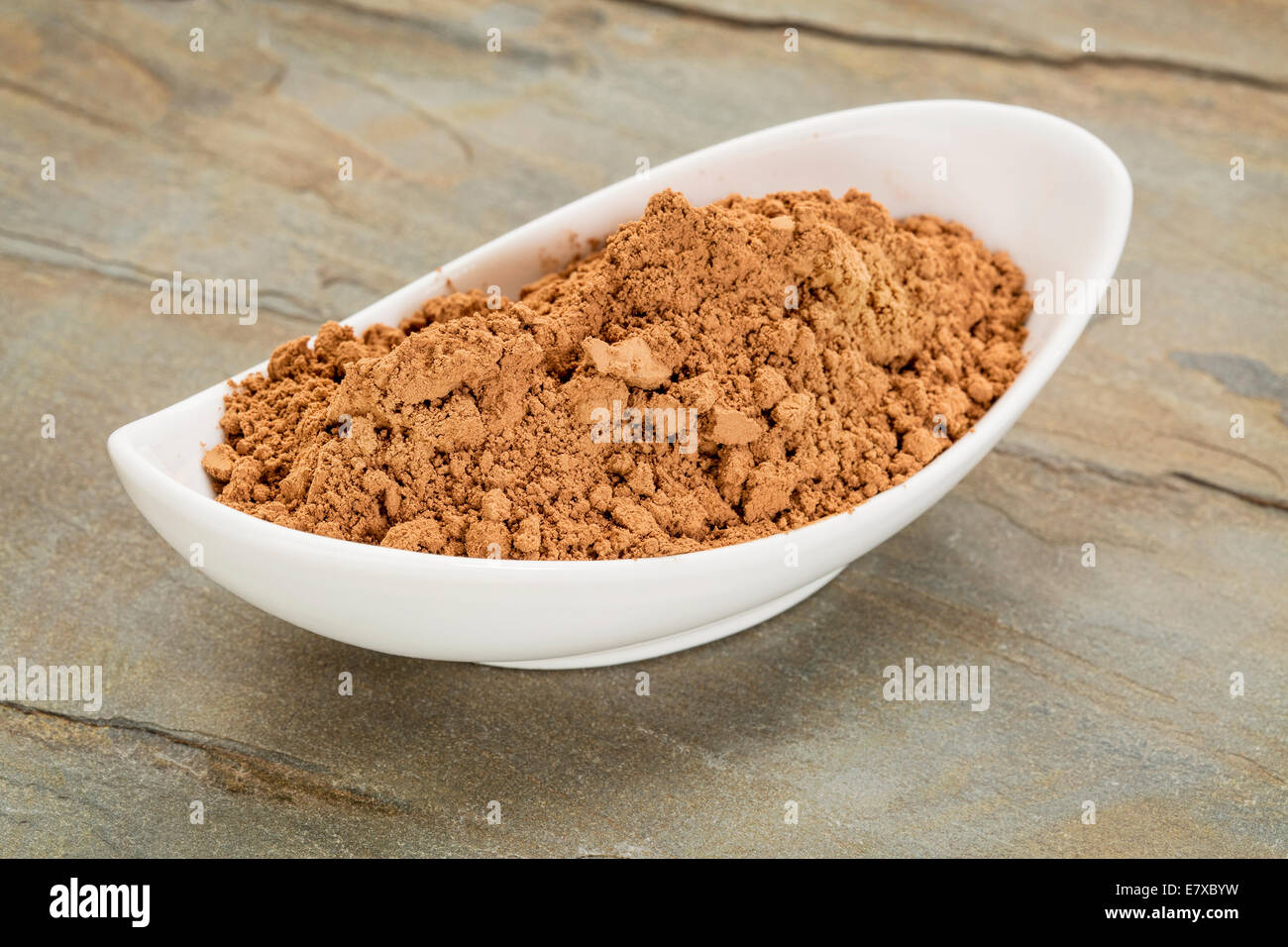 Una piccola ciotola di ceramica di materie organiche in polvere di cacao ricco di antiossidanti e di magnesio Foto Stock