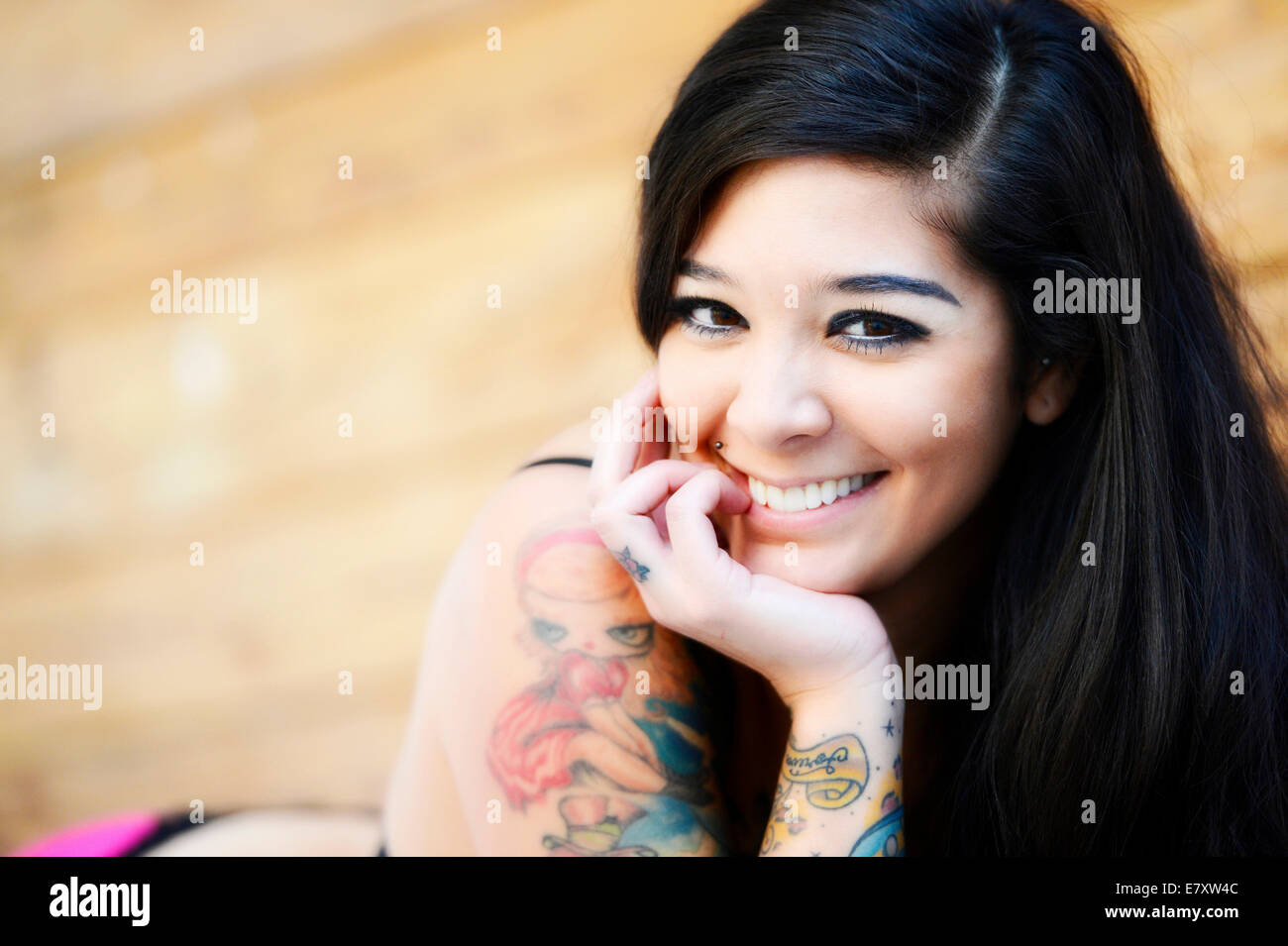 Giovane donna sorridente con tatuaggi Foto Stock