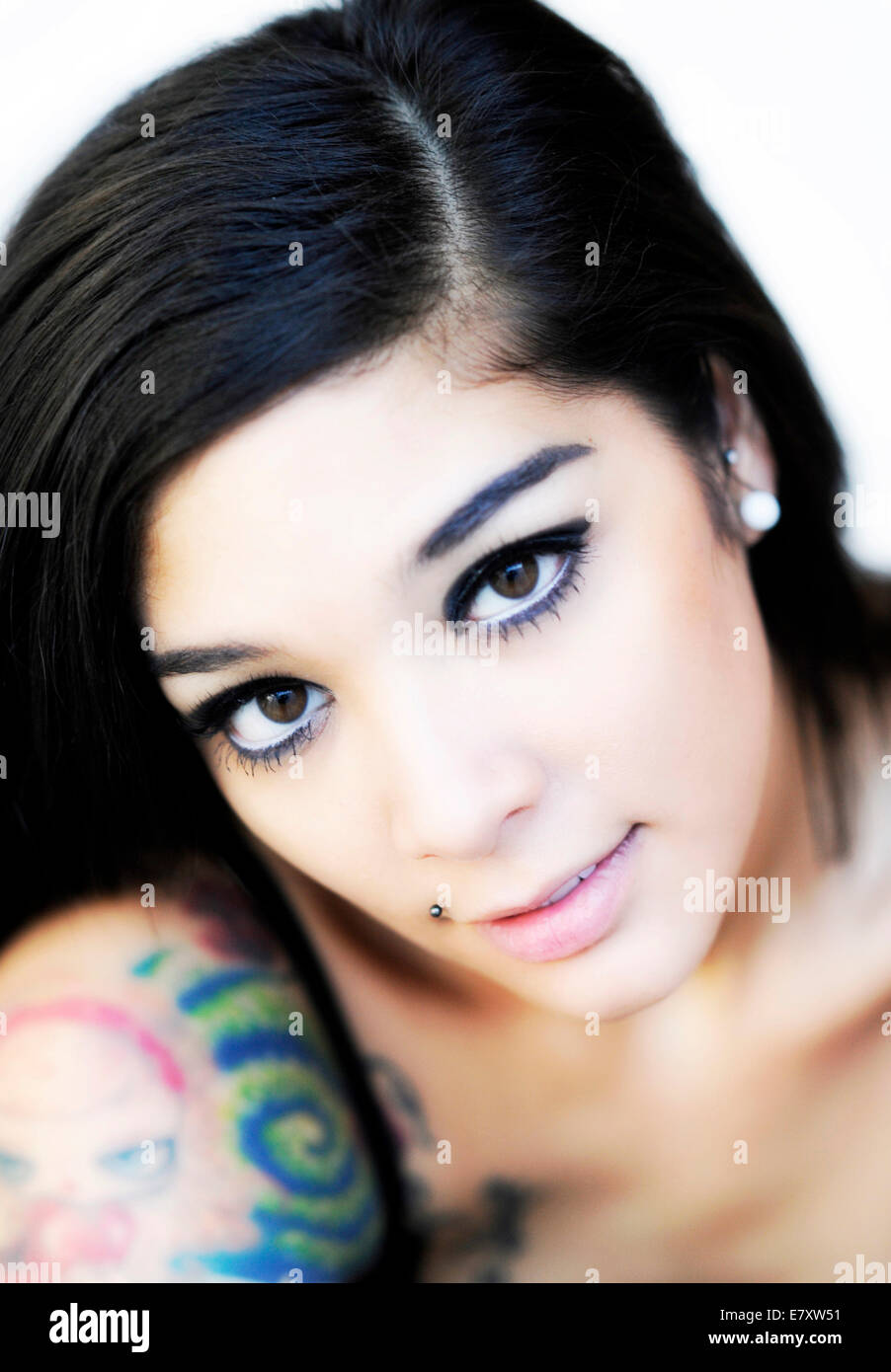 Giovane donna con tatuaggi e capelli scuri Foto Stock