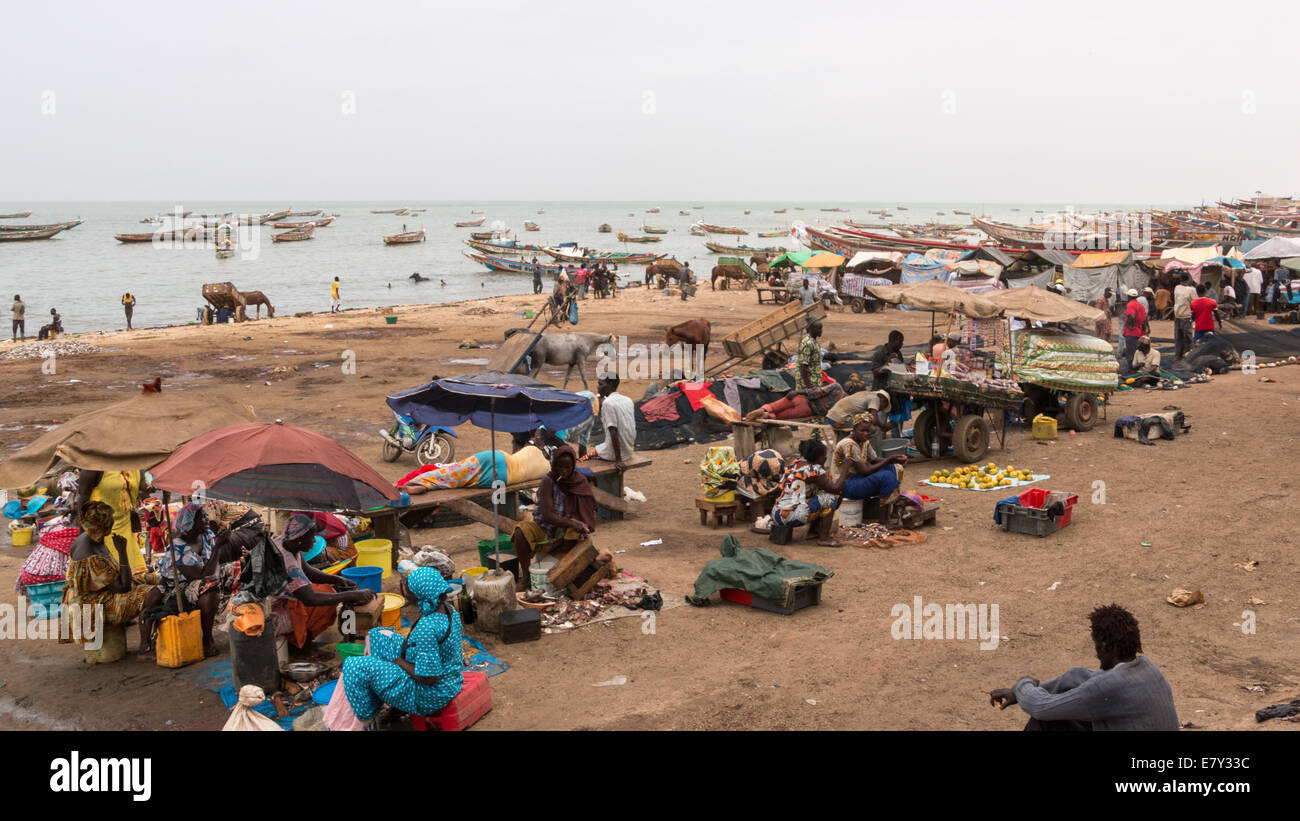 Mbour, Senegal - Luglio 2014: Diverse centinaia di persone si riuniscono presso il locale mercato del pesce di Mbour per comprare e vendere il quotidiano ca Foto Stock