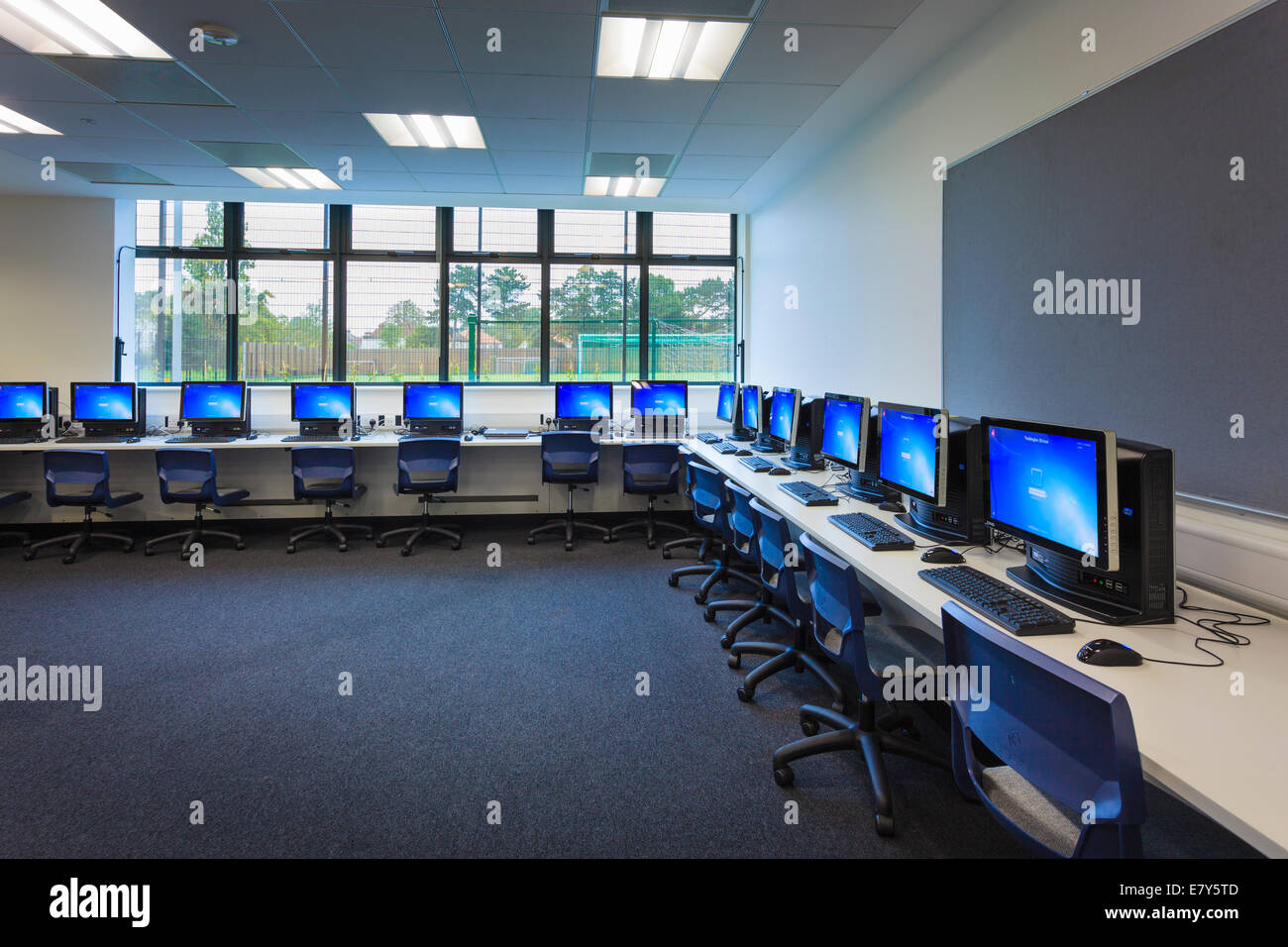 Gli schermi dei computer attorno alle pareti della sala computer di Teddington Sixth Form College. Foto Stock