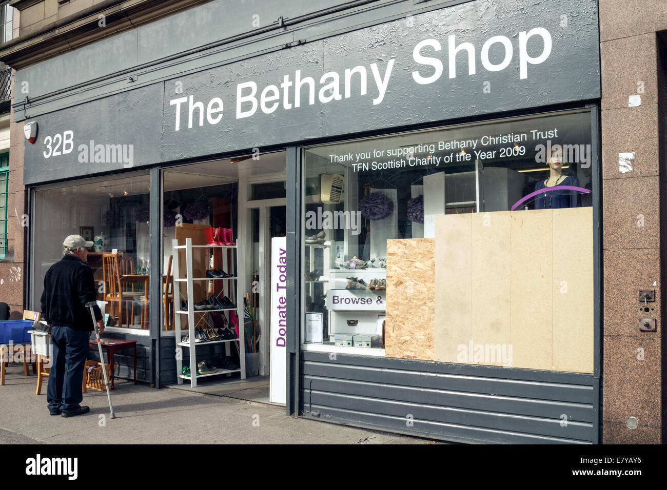 Il vecchio uomo che guarda la finestra di visualizzazione del Betania carità Shop su Leith Walk, Edimburgo Foto Stock