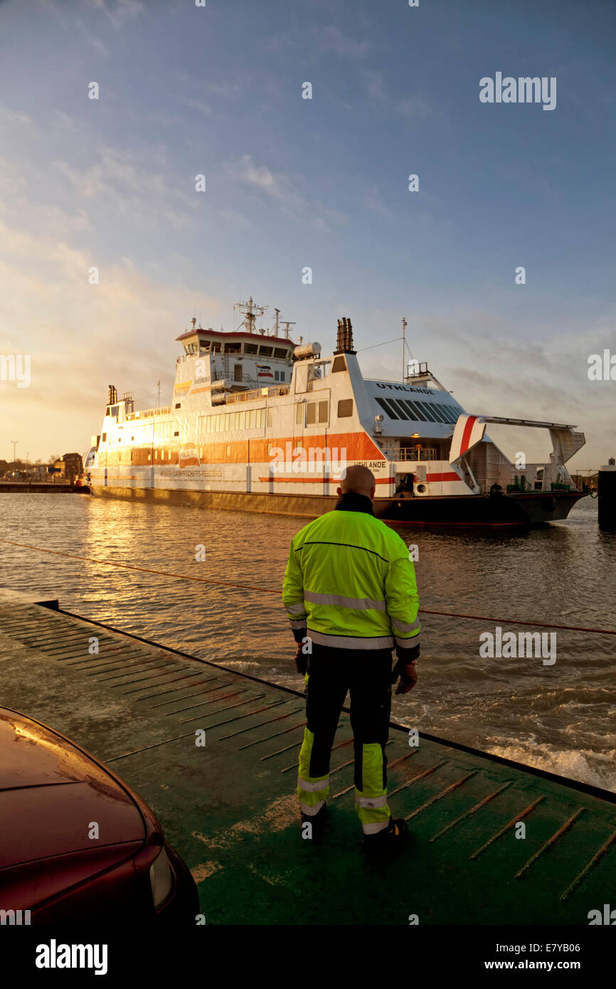 Traghettatore di anime in piedi sulla prua di una nave traghetto in arrivo al porto di Wyk sull isola di Föhr dove un altro traghetto è ormeggiata Foto Stock