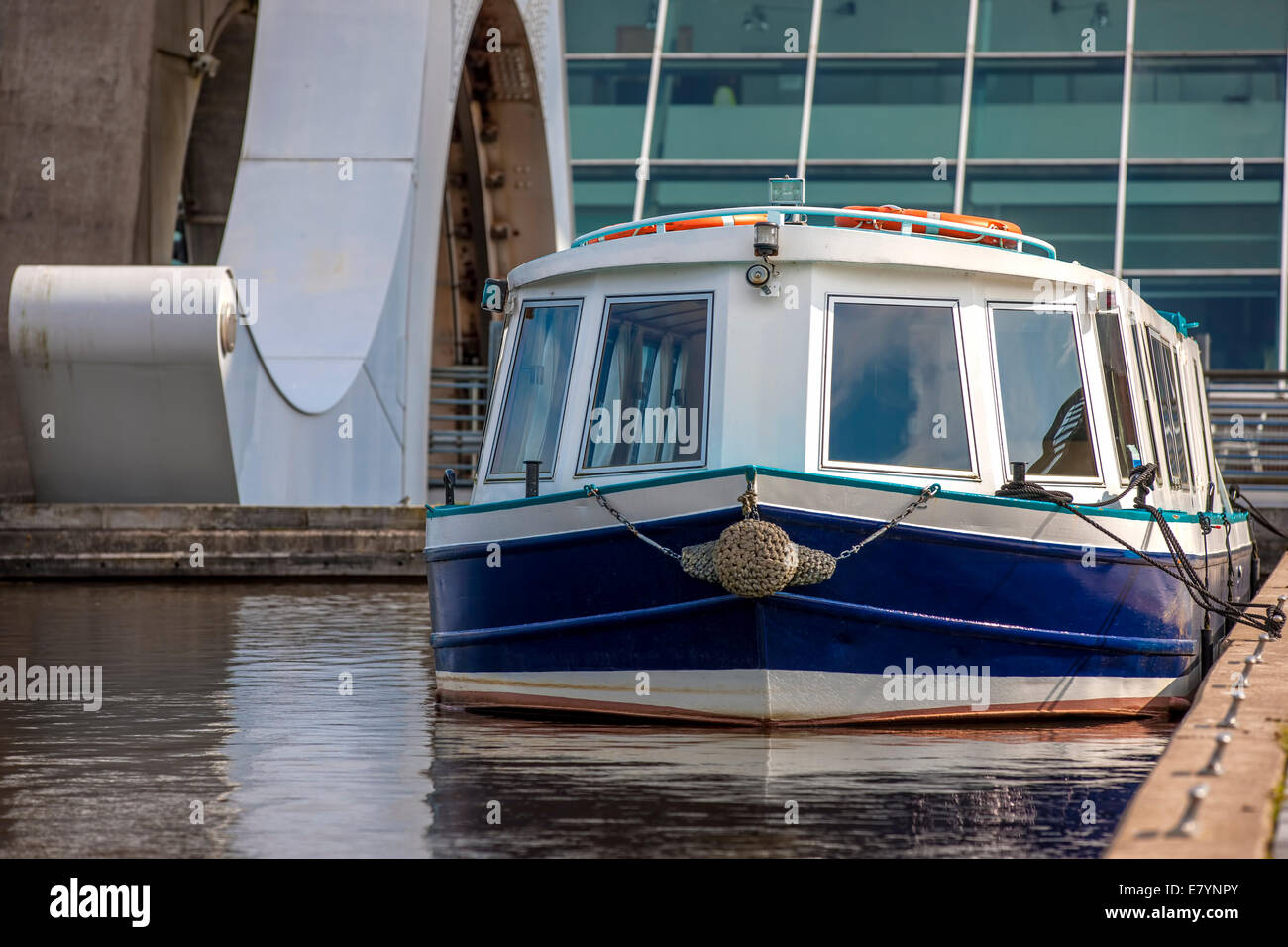 Bianco e blu imbarcazione attraccata vicino a Falkirk Wheel, Scozia. Il Falkirk Wheel è una macchina rotante sollevatore a Falkirk, Scozia Foto Stock