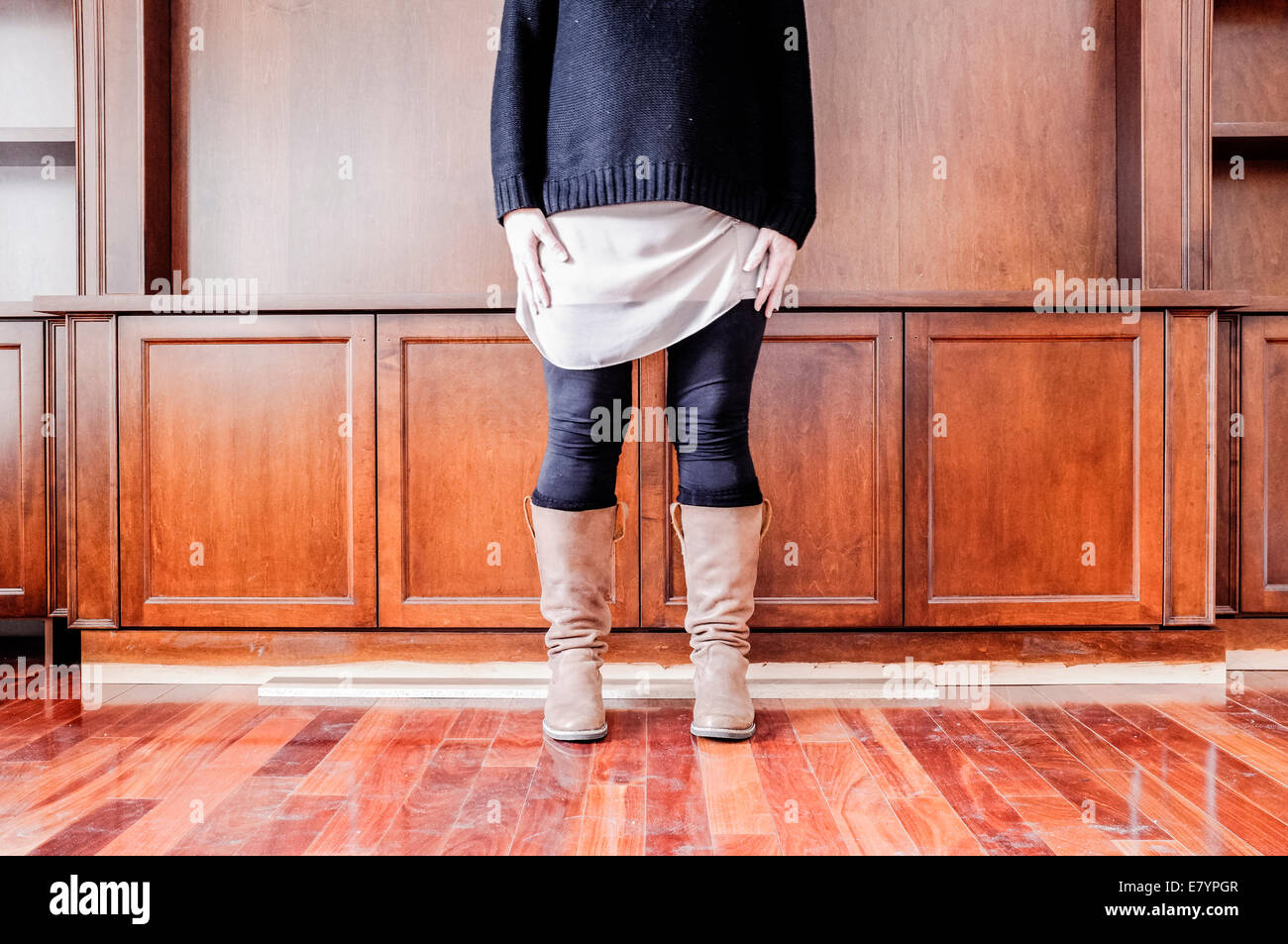 Donna che indossa galoshes in piedi nella parte anteriore della parete Foto Stock
