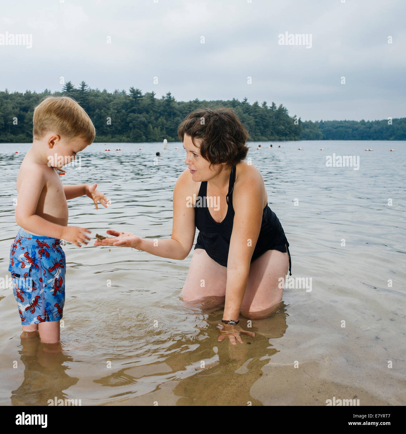 Madre e figlio (4-5 anni) giocando in acqua Foto Stock