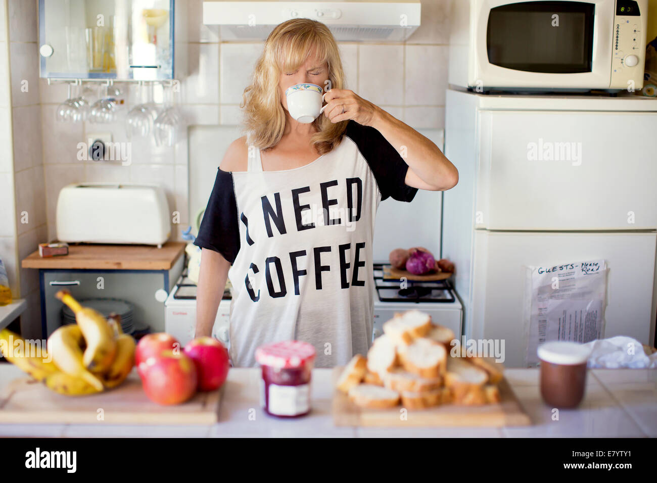 Donna di bere il caffè in cucina Foto Stock