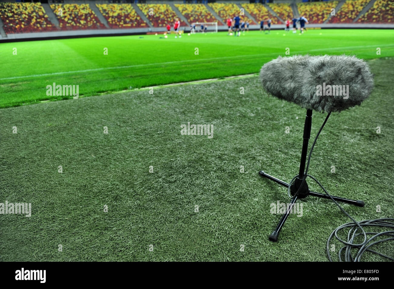 Sport professionale il microfono su un campo di calcio con i giocatori della formazione in background Foto Stock