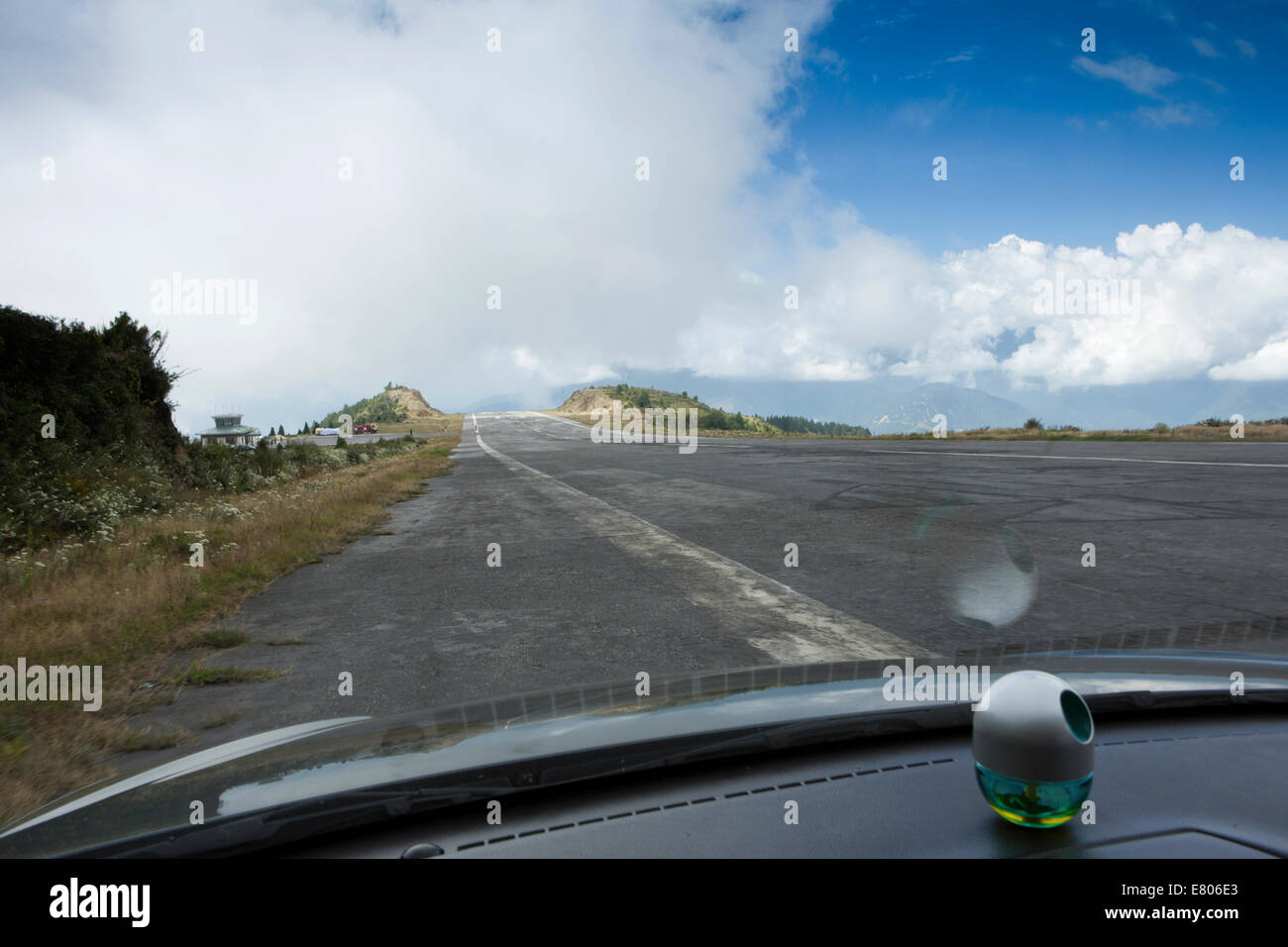 Il Bhutan orientale, Yongphula, aeroporto nazionale, vista dalla macchina di guida in pista verso il basso al terminale Foto Stock