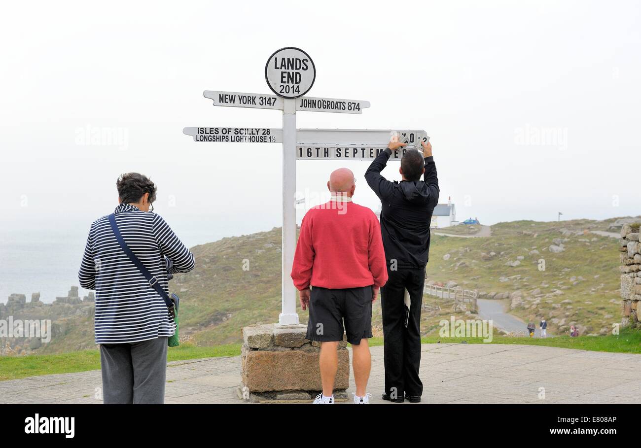 Una coppia americana da Easton Maryland in attesa di avere la loro fotografia scattata a Lands End cartello turistico post Cornwall Regno Unito Foto Stock