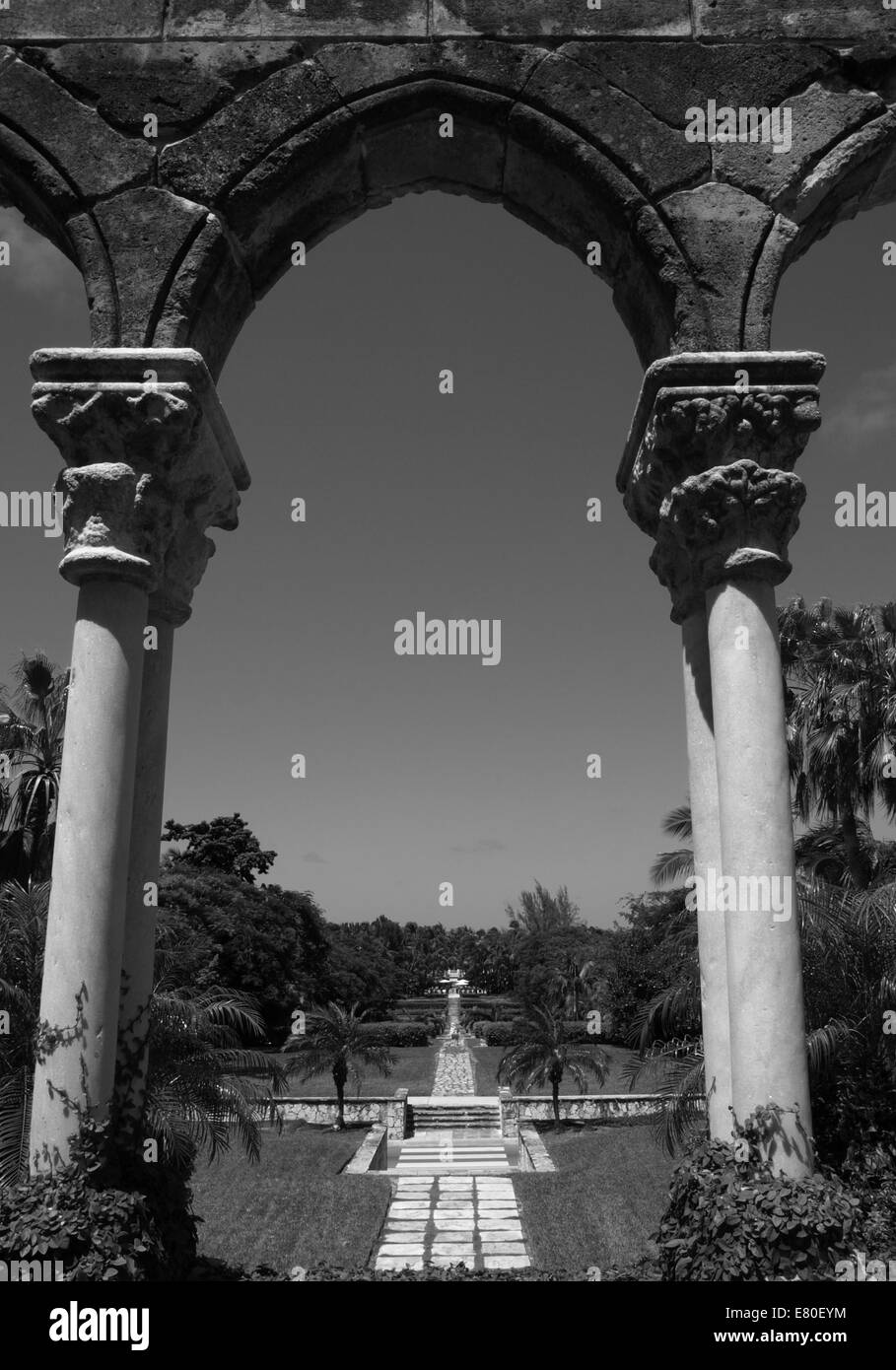 Guardando attraverso un arco di pietra in un bellissimo giardino in Bahamas Foto Stock