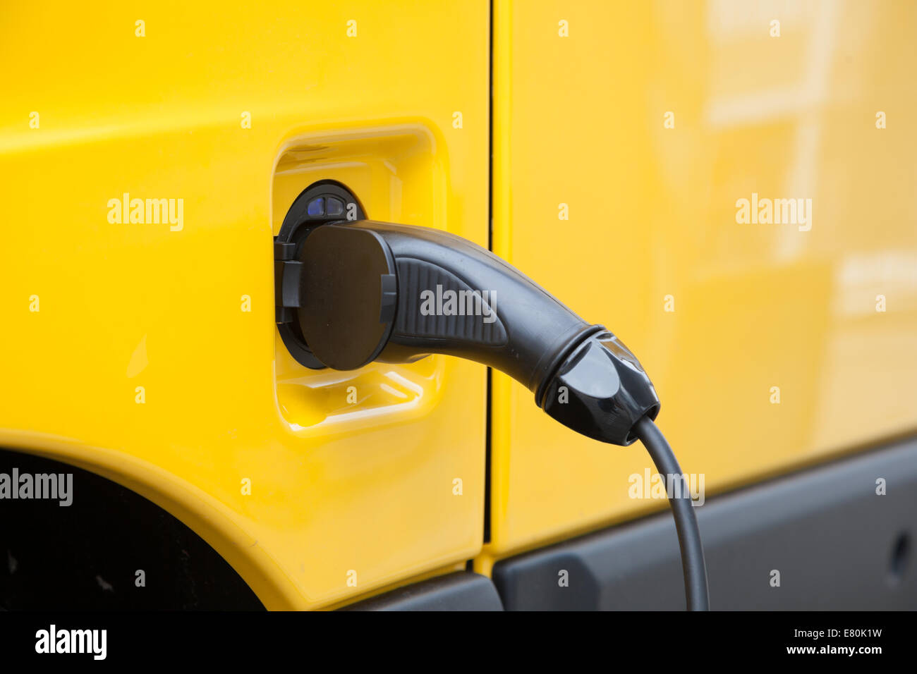 Connettore maschio e cavo in corrispondenza di un giallo auto elettrica Foto Stock