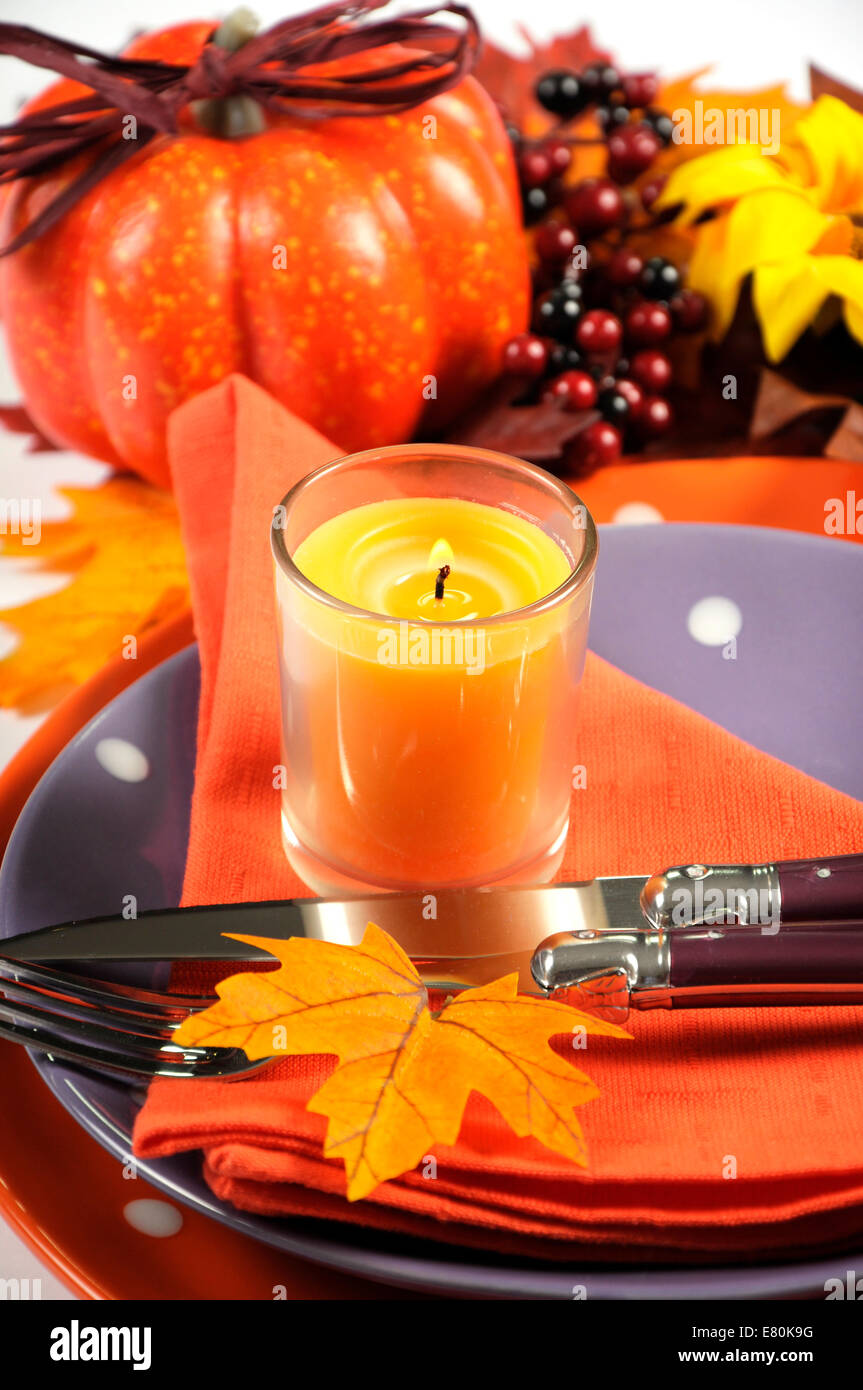 Happy Halloween o festa del Ringraziamento luogo tabella di impostazione con autunno cadono le foglie, zucca, candela accesa e di colore arancione e viola Foto Stock