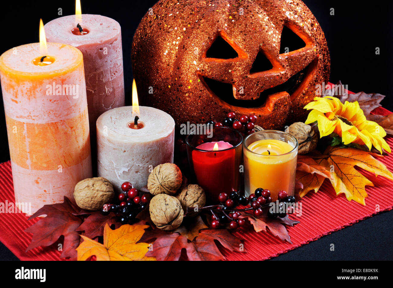Happy Halloween party tabella centrotavola con orange glitter jack-o-lantern zucca con candele accese e in autunno cadono le foglie Foto Stock