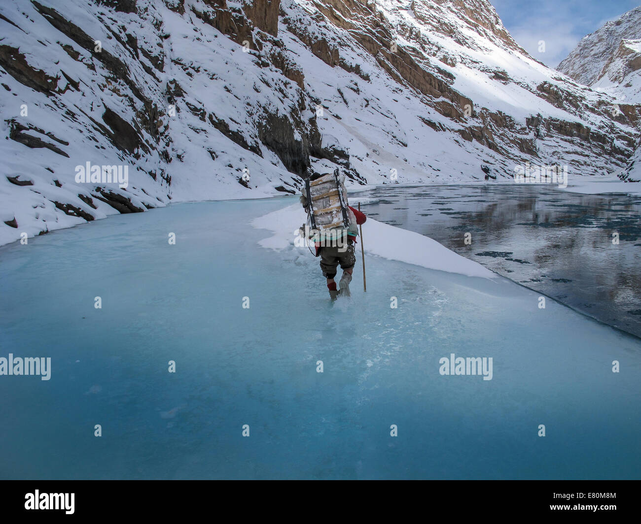 Porter è portare i bagagli su Zanskar fiume durante Chadar trek Foto Stock