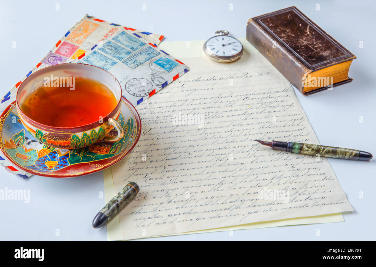 Scena Vintage della vecchia lettera manoscritta, us airmail buste, antica penna stilografica, orologio da tasca, porcellana cinese, tazza da tè Foto Stock