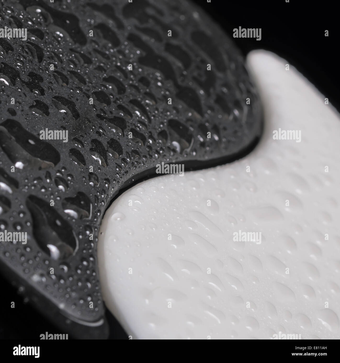 Il simbolo yin-yang di tessitura della pietra, il segno dei due elementi con pochi acqua su sfondo nero Foto Stock