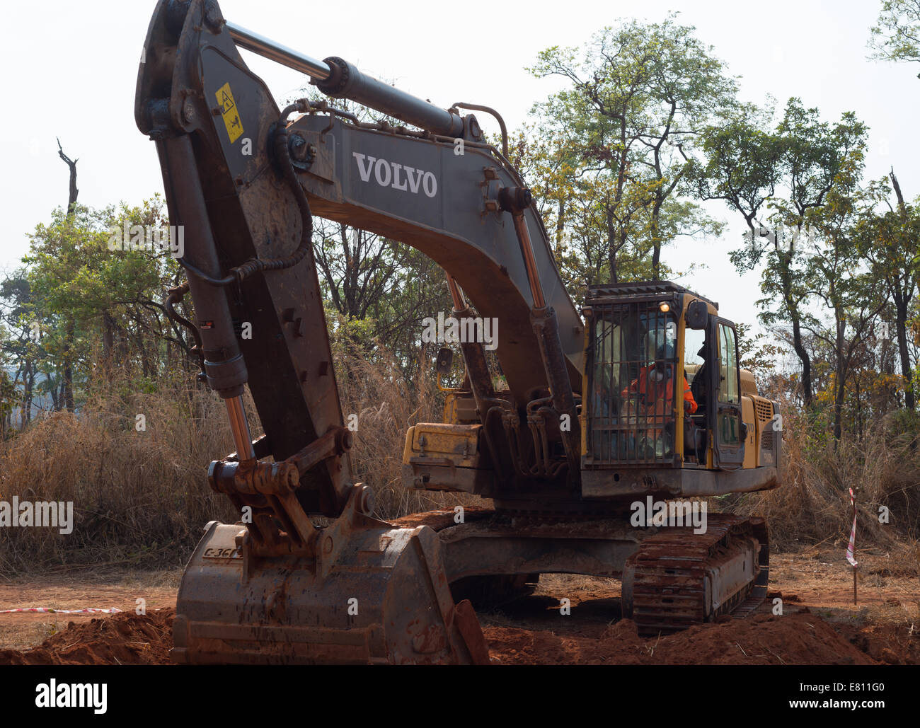 Un affittato 30 ton escavatore Volvo scava un buco come parte di un progetto di costruzione di una grande miniera a cielo aperto. Foto Stock