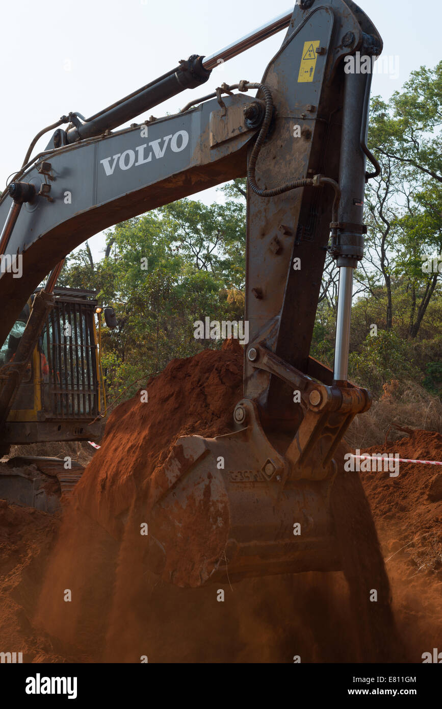 Un affittato 30 ton escavatore Volvo scava un buco come parte di un progetto di costruzione di una grande miniera a cielo aperto. Foto Stock