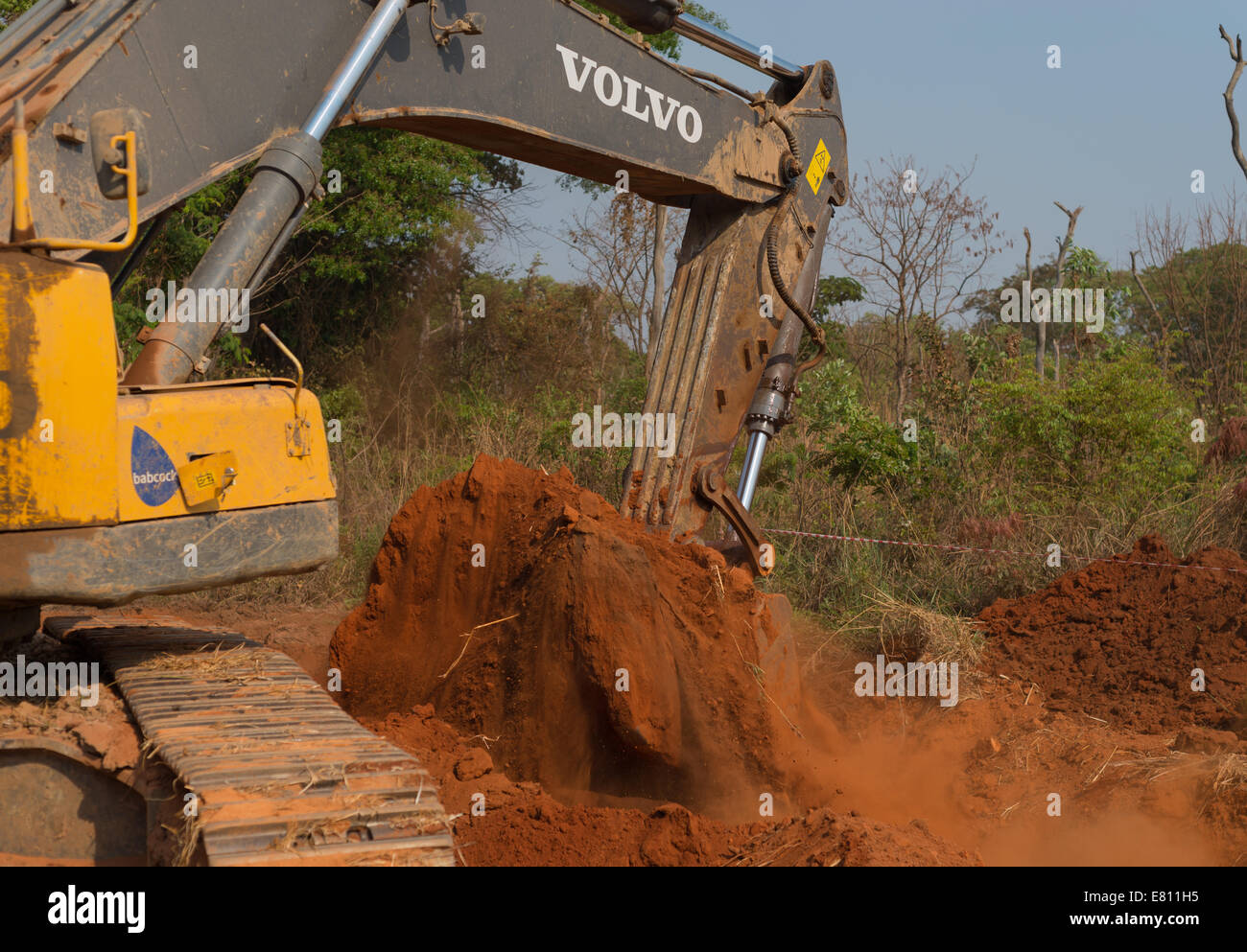 Un affittato 30 ton escavatore Volvo scava un buco come parte di un progetto di costruzione di una grande miniera a cielo aperto. Foto Stock