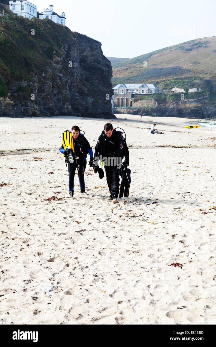 Due subacquei attrezzatura subacquea aria serbatoi serbatoio umido tuta adatta per apparecchi respiratori a piedi dal mare sulla spiaggia divers Foto Stock