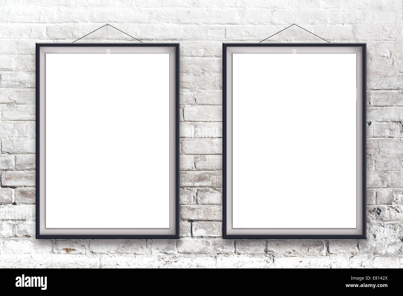 Due vuoti di verniciatura verticale poster nel riquadro nero appesa su bianco muro di mattoni. Foto Stock